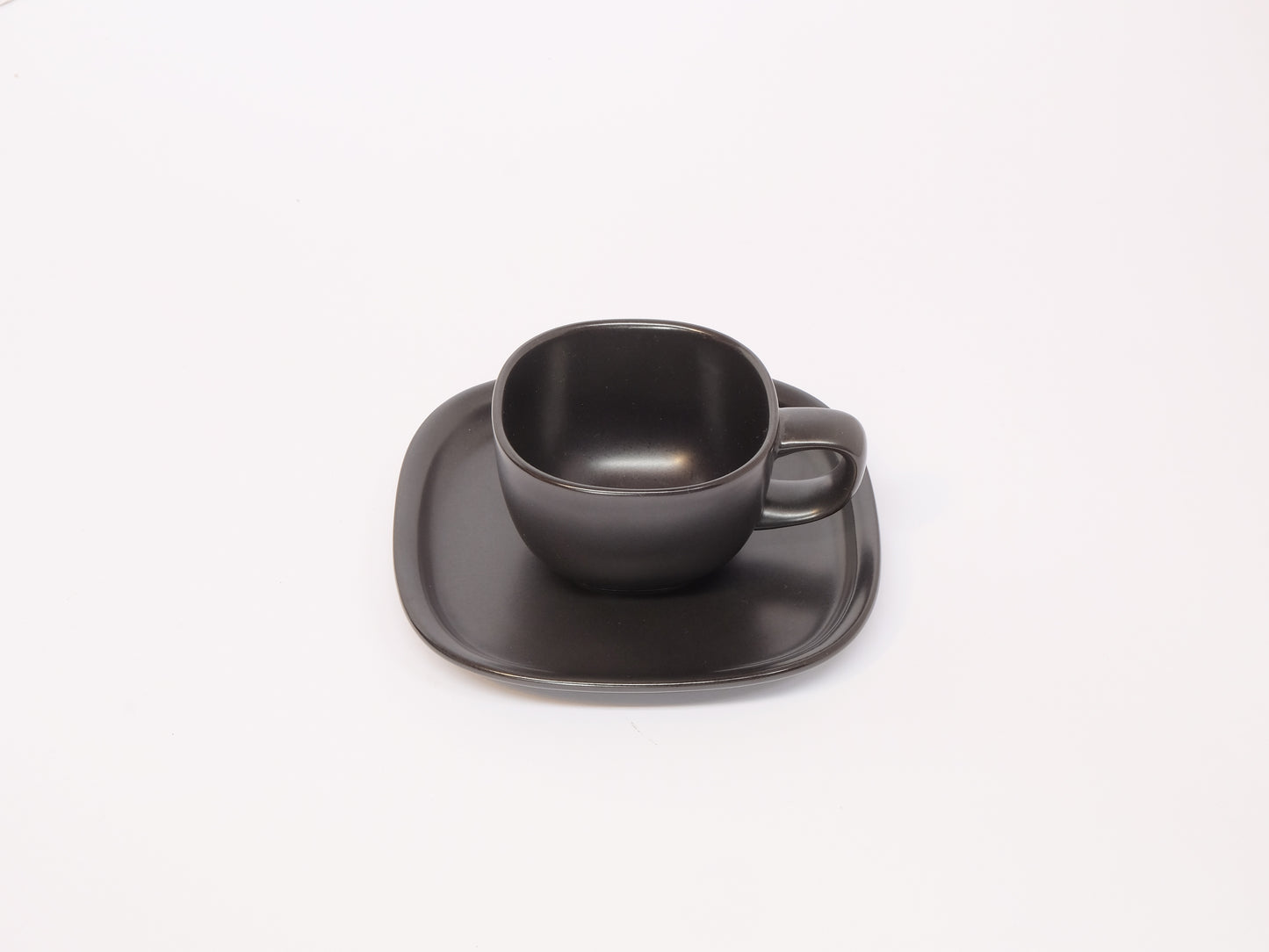 Black and white coffee cup with matching saucer by 柳宗理, sleek ceramic design, minimalist style for elegant coffee moments.