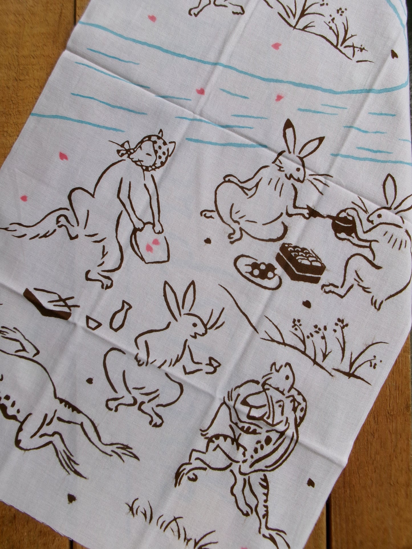 Japanese tenugui towel with cherry blossom and floral pattern for hanami, crafted by Kamawanu, showcasing traditional textile design.