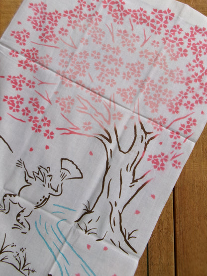 Japanese tenugui towel featuring cherry blossom and picnic scene design by Kamawanu, perfect for Hanami or decorative use.