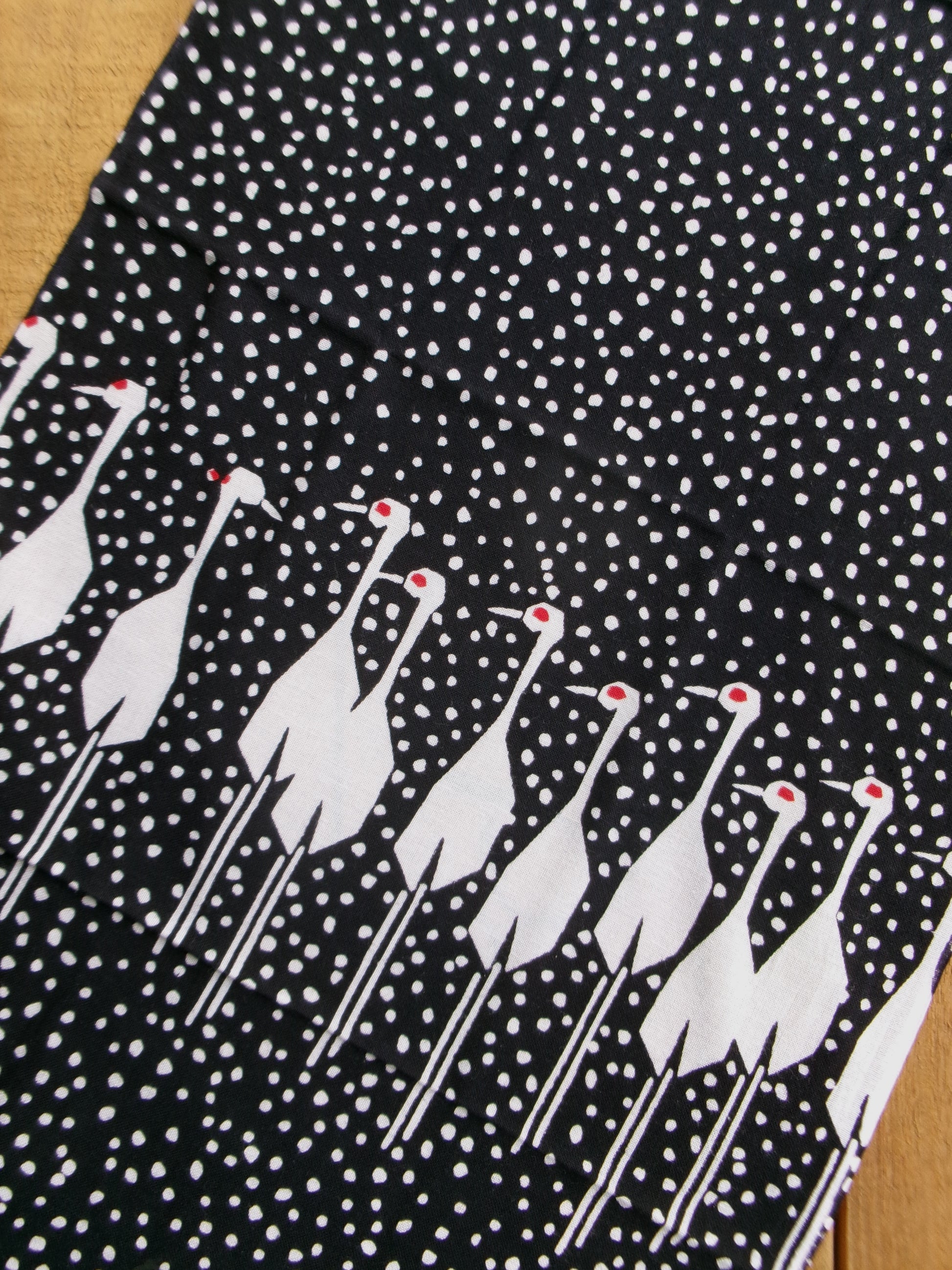 Traditional tenugui cloth featuring a snow crane design by Kamawanu, showcasing intricate crane and snowflake patterns.