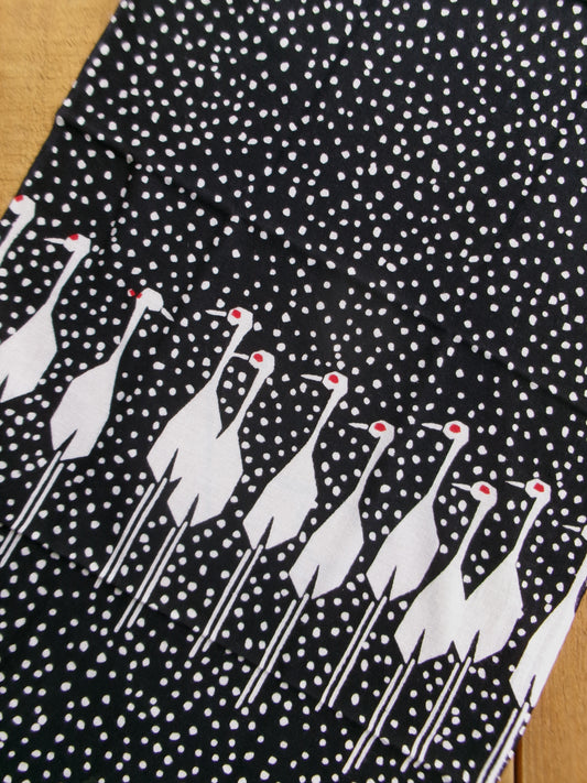 Traditional tenugui cloth featuring a snow crane design by Kamawanu, showcasing intricate crane and snowflake patterns.