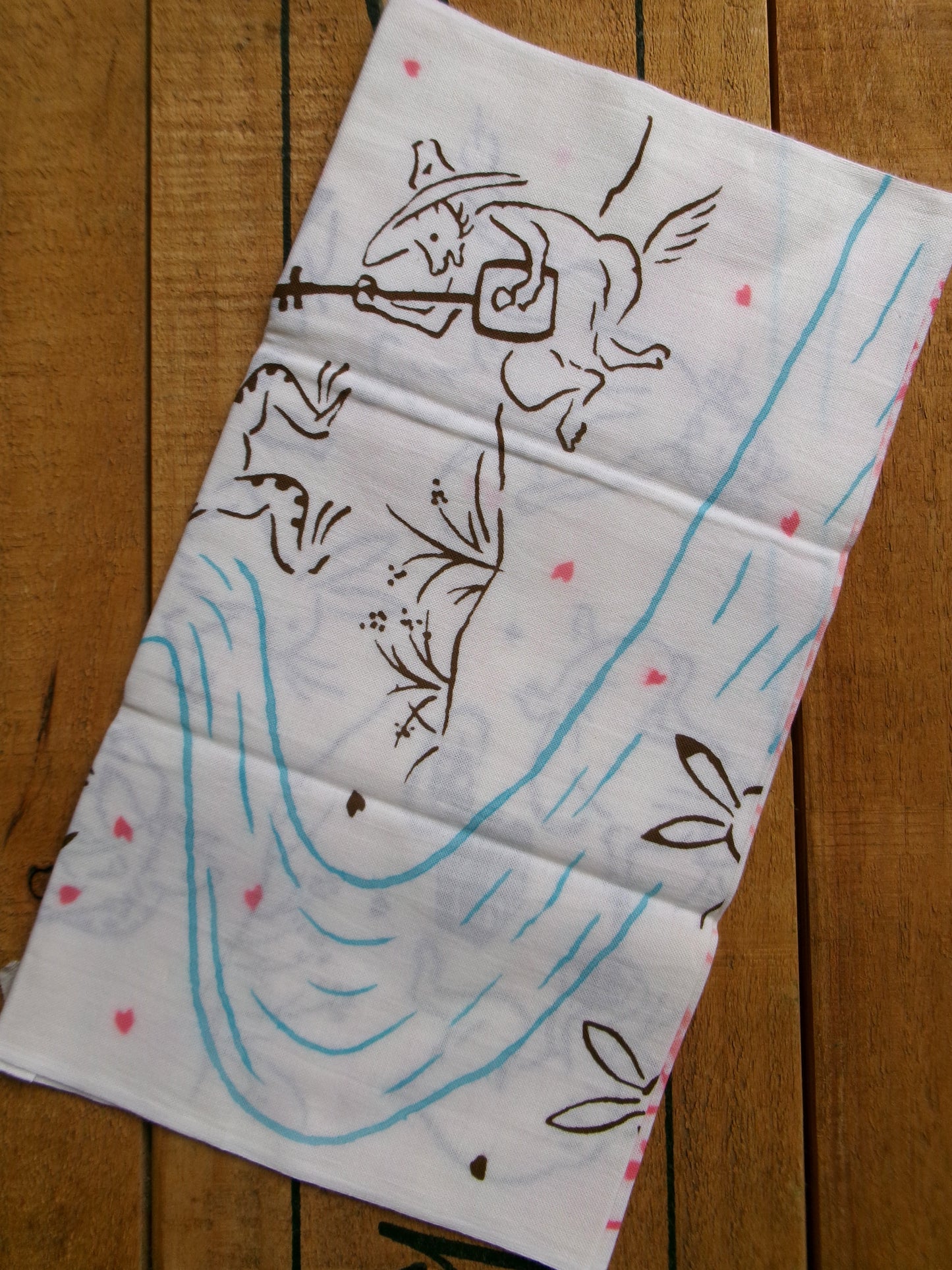 Japanese tenugui towel featuring cherry blossom and picnic scene, traditional fabric from Kamawanu with floral print design.