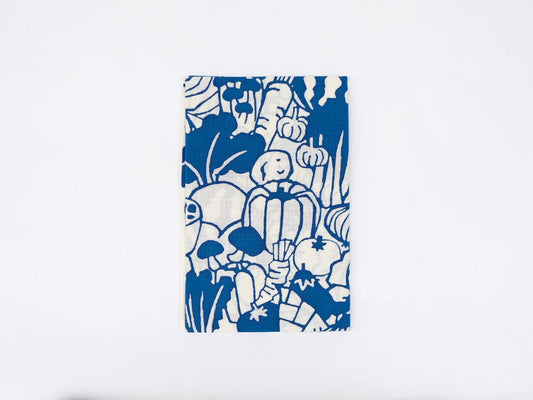 Japanese tenugui cloth featuring colorful vegetable illustrations by Kamawanu, showcasing a vibrant vegetable pattern on blue fabric.