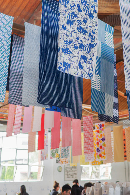 Japanese tenugui towel featuring colorful vegetable patterns in blue, by Kamawanu, showcasing traditional fabric design.