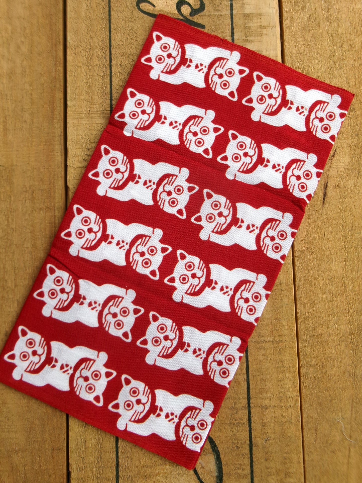 Japanese tenugui featuring lucky cat and traditional patterns by Kamawanu, showcasing intricate textile design and vibrant colors.